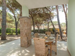 a table and chairs on a patio with a stone fireplace at Holiday Home San Pietro Blue by Interhome in Codaruina