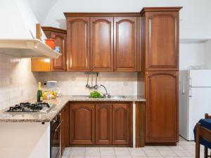 a kitchen with wooden cabinets and a sink at Holiday Home Le Antiche Volte - SLR215 by Interhome in Cipressa