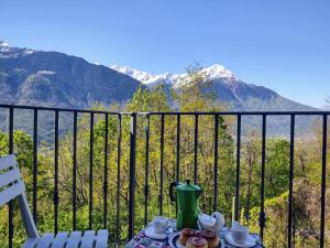 una mesa con tetera en la parte superior de un balcón con montañas en Holiday Home Casa Kiwi by Interhome, en Cercino