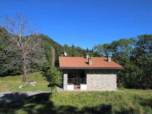 a small house with a red roof in a field at Holiday Home Alpe by Interhome in Brissago Valtravaglia