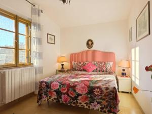 1 dormitorio con 1 cama con colcha de flores y 2 lámparas en Apartment Conte Francesco I-2 by Interhome, en Certaldo