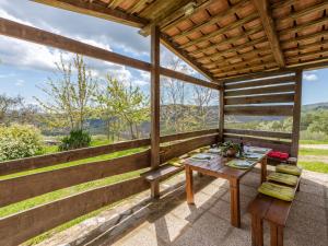 porche de madera con mesa y banco en Holiday Home Podere Casidote by Interhome, en Montieri