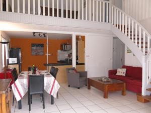 sala de estar con mesa y sofá rojo en Holiday Home Les Embruns - RHU100 by Interhome, en Sarzeau