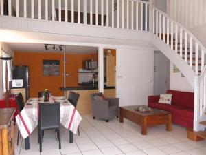a living room with a table and a red couch at Holiday Home Les Embruns by Interhome in Sarzeau