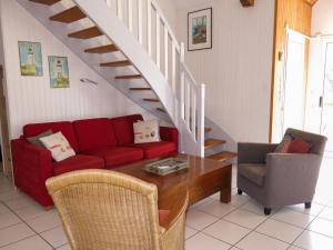 a living room with a red couch and a table at Holiday Home Les Embruns by Interhome in Sarzeau +19 photos