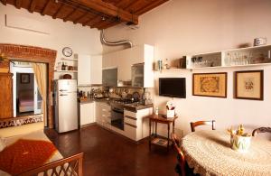 een keuken met een koelkast en een tafel in een kamer bij Dimora Coccapani in Pisa