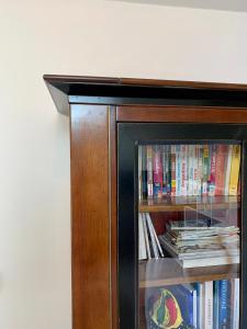 a wooden book shelf with books on it at Appart chic et cosy/centre ville/ 20min de Paris in Maisons-Laffitte