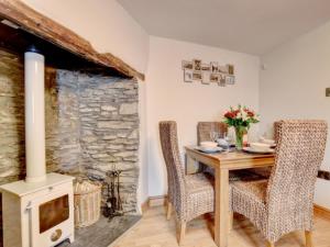 ブラントンにあるHoliday Home Cosy Cottage by Interhomeのダイニングルーム(テーブル、椅子、石造りの暖炉付)