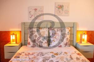 ein Schlafzimmer mit einem Bett mit zwei Leuchten in der Unterkunft Quinta de Belmonte in Estremoz