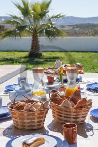 einen Tisch mit Brotkörben und Gläsern Orangensaft in der Unterkunft Quinta de Belmonte in Estremoz