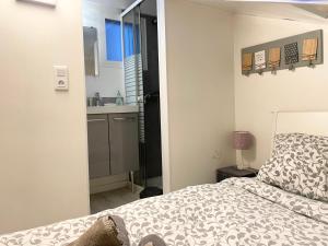 a bedroom with a bed and a small kitchen at Homelivia, ATTIC ROOM -Mansardé sous les toits de Nice in Nice