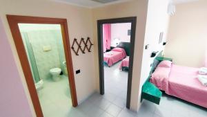 una camera con due letti e un bagno con specchio di Hotel Mater Mediterranea a Senorbì