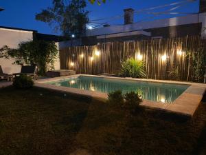 a swimming pool in front of a fence at night at Alas in Roldán