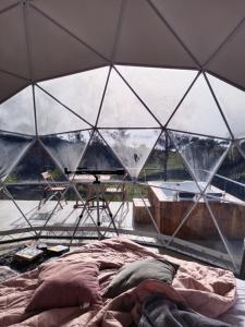 a tent with a bed and a tub in it at Stellarium Glamping in Murillo