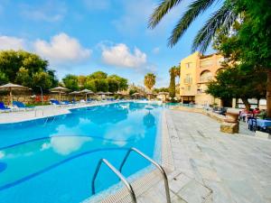 a large swimming pool with blue water at basillica 3 bedrooms apartment in Paphos