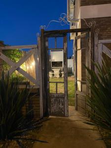 an open door to a pasture with a cow in the background at Alas in Roldán
