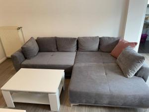 ein Wohnzimmer mit einem grauen Sofa und einem Tisch in der Unterkunft Apartment Riff by Interhome in Norddeich