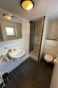 ein Bad mit einem Waschbecken, einer Dusche und einem WC in der Unterkunft Apartment Riff by Interhome in Norddeich