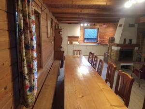 einen langen Holztisch in einem Zimmer mit Stühlen in der Unterkunft Dom w Czostkowie na Suwalszczyźnie in Rospuda
