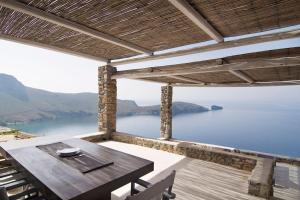 a table and chairs on a patio with a view of the water at Dreamy Cycladic Luxury Summer Villa 1 in Serifos Chora
