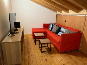 a living room with a red couch and a table at Casa Arenga in Almádena