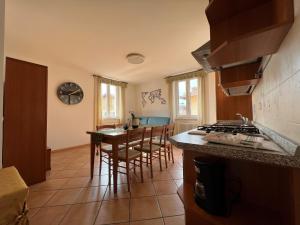 a kitchen with a counter and a table with chairs at Appartamenti Baia Azzurra 6. in Nago-Torbole