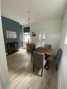 a dining room with a table and chairs and a fireplace at Ifan cottage - two bedroom cottage in Meliden