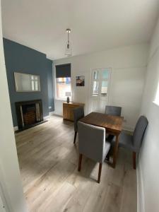 ein Esszimmer mit Tisch und Stühlen und einem Kamin in der Unterkunft Ifan cottage - two bedroom cottage in Meliden