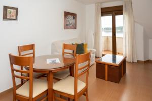 salon ze stołem, krzesłami i kanapą w obiekcie Apartamentos A Laxe w mieście O Grove