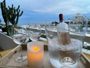 a candle and wine glasses on a table with a view at Appartement bord de mer Villeneuve Loubet in Villeneuve-Loubet