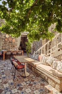 een patio met een bank en een tafel en stoelen bij Morisi Avlu in Alacati