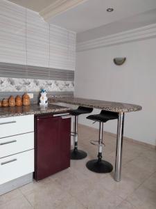 a kitchen with a counter and two bar stools at Studio à Hammam Sousse in Hammam Sousse