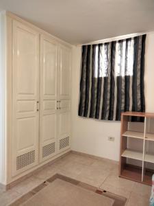 a room with white cabinets and a window at Studio à Hammam Sousse in Hammam Sousse