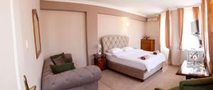 a bedroom with a bed and a couch and a chair at Family Hotel Victoria Gold in Mineralni Bani