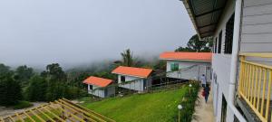 twee huizen met oranje daken op de top van een heuvel bij THE CLOUD KINABALU- Chalet in Ranau