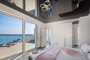 1 dormitorio con cama y ventana grande en Beachfront Holiday Home - Private Heated Pool, en Mimice