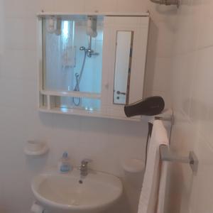 een witte badkamer met een wastafel en een spiegel bij A casa dell'artista in Cefalù +15 foto's