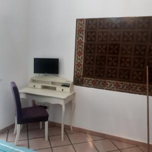 een bureau met een computer en een stoel in de kamer bij A casa dell'artista in Cefalù