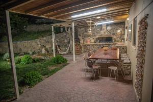 patio ze stołem i krzesłami pod dachem w obiekcie KOS UNIQUE w mieście Kos
