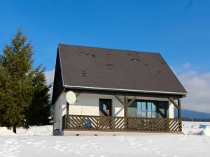 a small house with a black roof in the snow at Holiday Home Holiday Hill 51 by Interhome in Lauterwasser