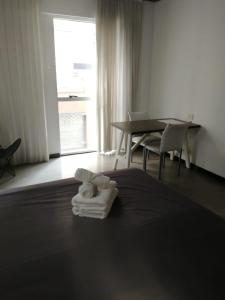a hotel room with a pile of towels on a bed at Babel Studios in Buenos Aires