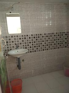 a bathroom with a sink and a tiled wall at Periyar Huts in Thekkady