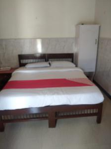 a bedroom with a large bed with a red blanket at Periyar Huts in Thekkady