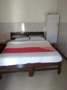 a bedroom with a bed with a red and white blanket at Periyar Huts in Thekkady