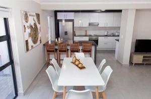a kitchen and dining room with a white table and chairs at MLMK Property 17 in Cape Town