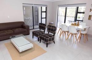 Una sala de estar con un sofá, una mesa y sillas. en MLMK Property 17, en Ciudad del Cabo