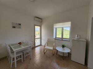 - un salon avec une table et un réfrigérateur dans l'établissement Apartment Željković, à Korčula