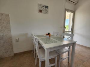 une salle à manger blanche avec une table et des chaises dans l'établissement Apartment Željković, à Korčula