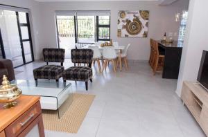 una sala de estar con una mesa y sillas en MLMK Property 17, en Ciudad del Cabo