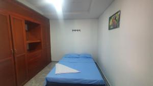 a small bedroom with a blue bed and a cabinet at Casa de descanso Cartagena-Turbaco in Turbaco